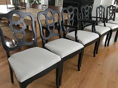 a set of six black and white chairs sitting on top of a hard wood floor