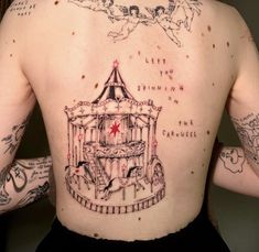 a man with tattoos on his back has a carousel tattoo on his left shoulder and chest