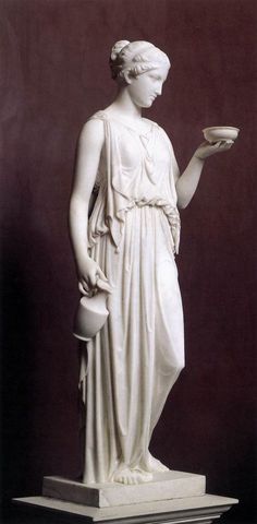 a white statue holding a bowl and plate