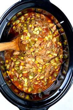 a slow cooker filled with meat, beans and corn is ready to be cooked