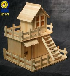 a wooden model of a house with stairs leading up to the roof