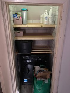 an open door shows the inside of a washer and dryer in a small room