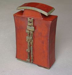 an old red box that has been turned into a decorative object with metal handles and latches