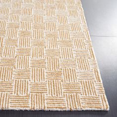 a beige and white rug on top of a wooden floor