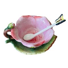 a pink flower shaped bowl with a toothbrush in it