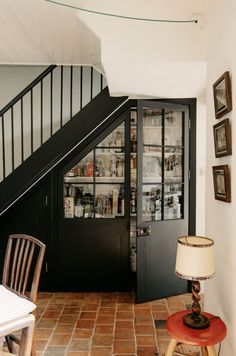 an entry way with a lamp, table and stairs leading to the upper floor area