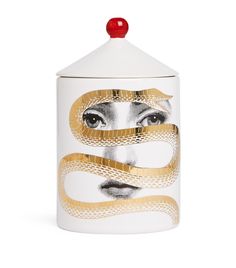 a white canister with a gold snake on the side and a red lid, in front of a white background