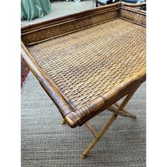 a wicker tray with wooden legs on carpeted floor