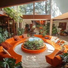 a living room filled with orange couches and lots of plants