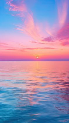 the sun is setting over the ocean with pink and blue clouds