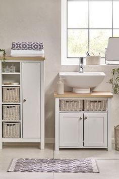 a bathroom with a sink, cabinet and rug