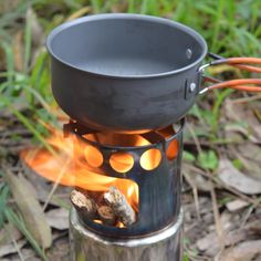 an outdoor cooking pot on fire in the woods