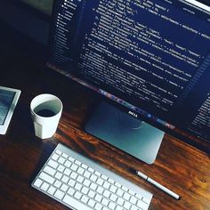 a computer monitor sitting on top of a wooden desk next to a keyboard and mouse