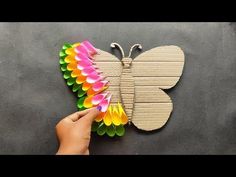 someone is making a butterfly out of paper