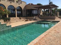 a house with a pool in front of it and steps leading up to the building