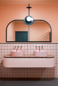 two sinks in a bathroom under a large mirror