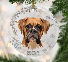 a glass ornament with a dog's face hanging from a christmas tree