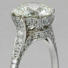 an antique style diamond ring with filigrees on the sides