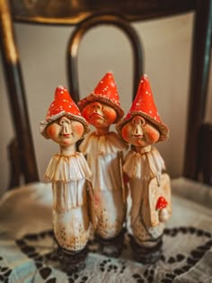 three little gnome figurines sitting on top of a table next to each other