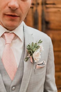 a man in a suit and tie with a boutonniere on his lapel