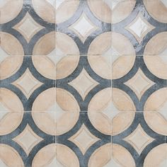 an artistic tile design with circles and rings in grey, beige and white colors on the floor