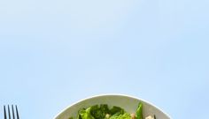 a white plate topped with lettuce next to a fork