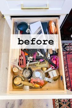 an open drawer filled with kitchen utensils on top of a wooden floor next to a rug