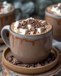 two cups filled with hot chocolate and marshmallows on top of each other