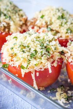 tomatoes stuffed with cheese and herbs on a baking sheet, ready to be cooked in the oven