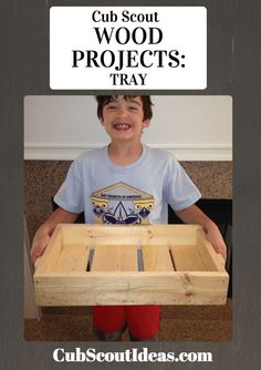 a young boy holding a wooden tray with wood projects in it and the caption cub scout