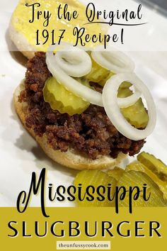 A mississippi beef slugburger on a bun topped with dill pickle slices and sliced onion with mustard and more pickles on the side Corinth Mississippi, Homemade Hamburger Patties, Cajun Meatloaf, Beef Stew With Dumplings, Paul Prudhomme, Easy Burger Recipe, Cafeteria Food, Burger Toppings, Hamburger Meat Recipes