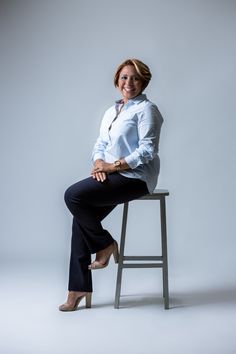 a woman sitting on top of a stool