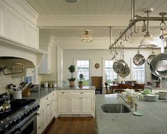 a large kitchen with white cabinets and stainless steel appliances