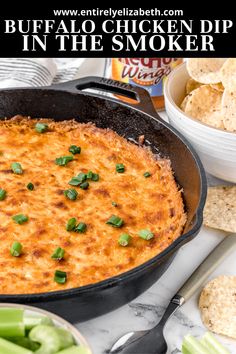 buffalo chicken dip in the skillet with celery and crackers