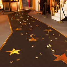 a black carpet with gold stars on it in front of a staircase and some stairs