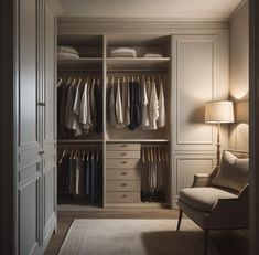 an open closet with clothes on hangers and a chair next to it in front of a lamp