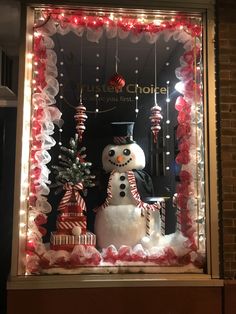 a window display with a snowman and christmas decorations