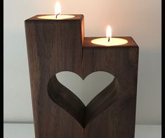 two wooden candles with hearts cut out of them