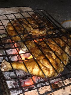 chicken is cooking on the grill with flames