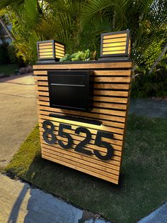 a television sitting on top of a wooden box next to a sidewalk and palm tree