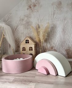 two pink and white dog beds sitting on the floor next to a toy house with a bed in it