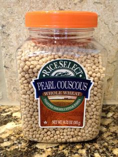 a jar of peal couscous sits on a granite countertop in front of a marble wall