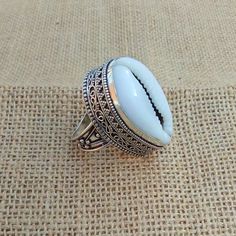 ---Cowrie Shell Ring--- Cowrie shells have a special meaning in Feng Shui and they are said to enhance the travel luck and also to strengthen long distance relationship. ... Like water, shells are a symbol of good communication, positive and healthy relationships & prosperity. _._._._._._._._._._._._._._._._._._ Gemstone: Cowrie Gemstone Size: 15x20 mm _._._._._._._._._._._._._._._._._._ Metal Type: Brass, 925 Sterling Silver Plated, Oxidized Weight :10-12 Gram (Approx) Made In: Jaipur, Indi