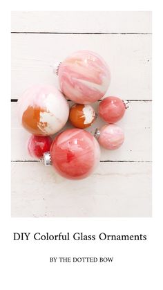 some pink and white marble balls on top of a wooden table with the title diy colorful glass ornaments by the dotted row