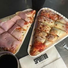 two slices of pizza sitting next to each other on top of paper plates with sauce