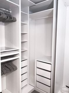 an empty closet with white shelves and drawers