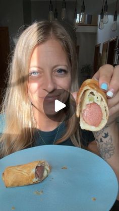 a woman holding a piece of food in front of her face and making a funny face