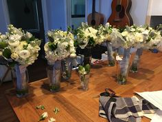 there are many vases with flowers in them on the table next to each other