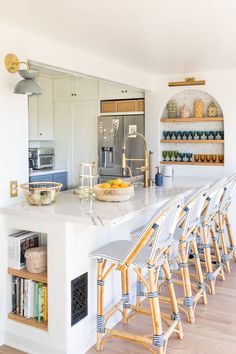 a kitchen with white counter tops and wooden stools