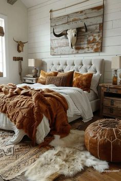 a bedroom with a bed, rugs and cow head on the wall above it